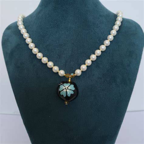 collar de madera y perlas sobre superficie neutra